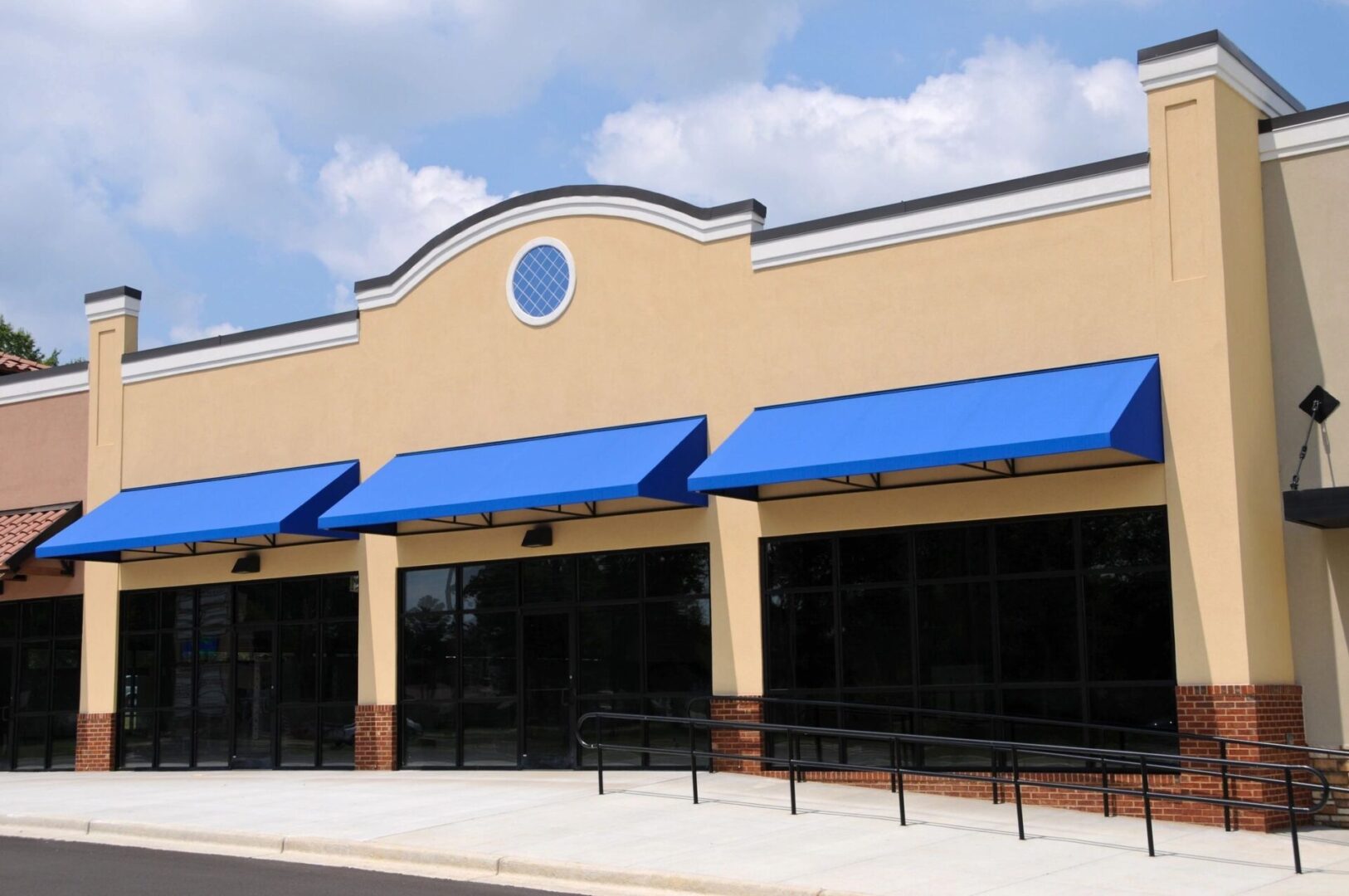 A store front with blue awnings and a white building.