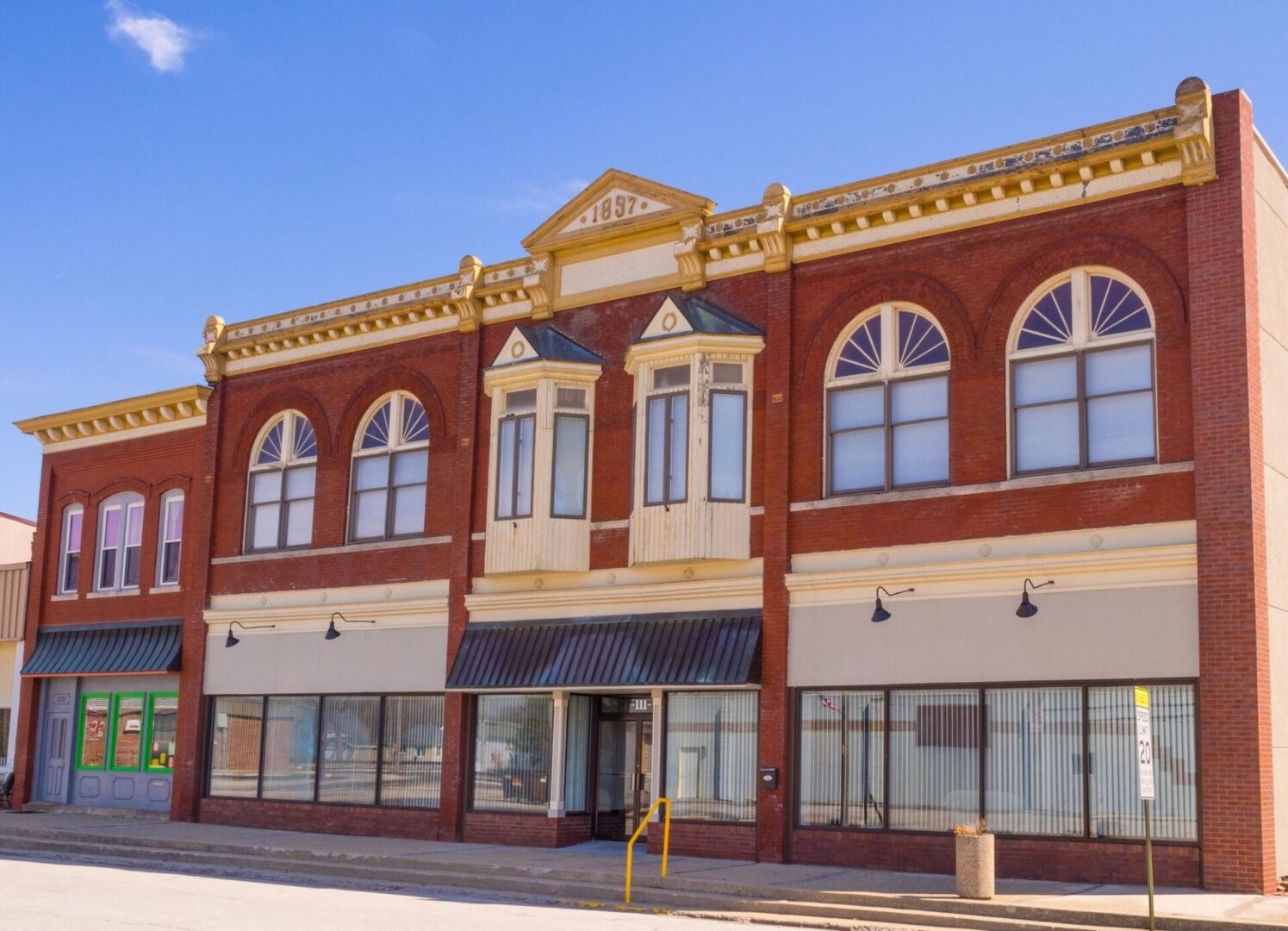 A large brick building with many windows on the street.