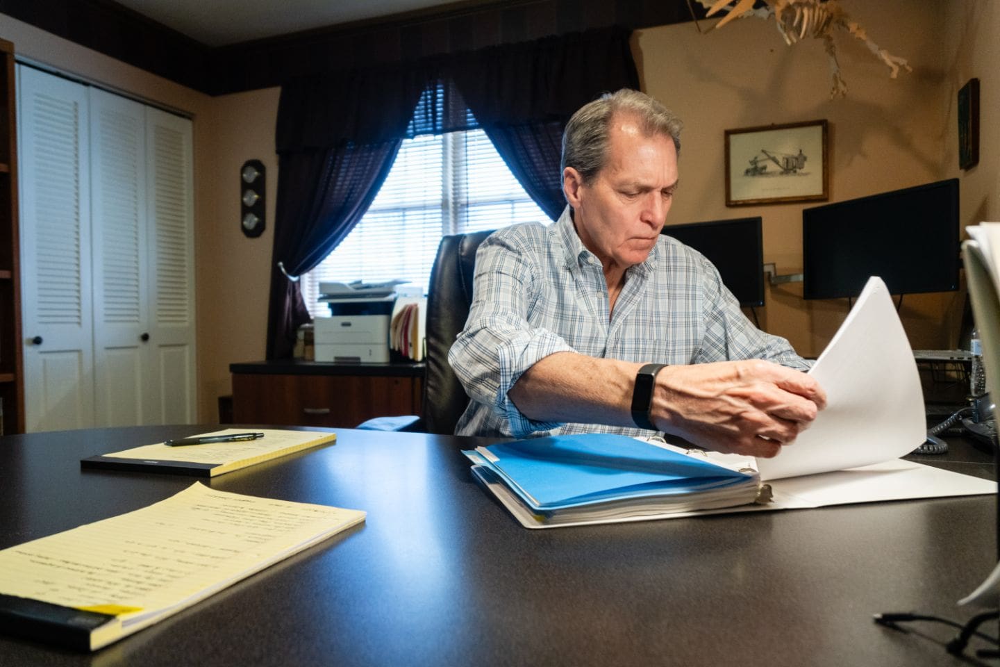 A man sitting at his desk reading papers.